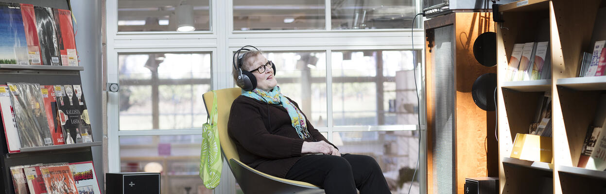 Personen lyssnar på musik i biblioteket. 